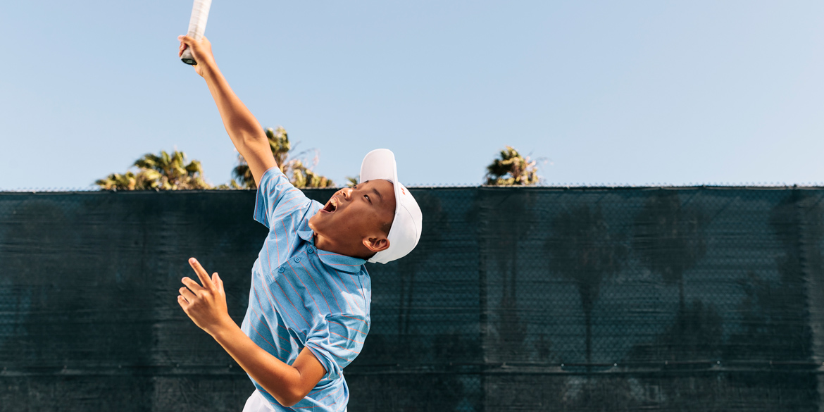 Youth athlete swinging a tennis ball in air Youth athlete swinging a tennis ball in air
