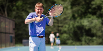 Adaptive male tennis player smiling with thumbs up.