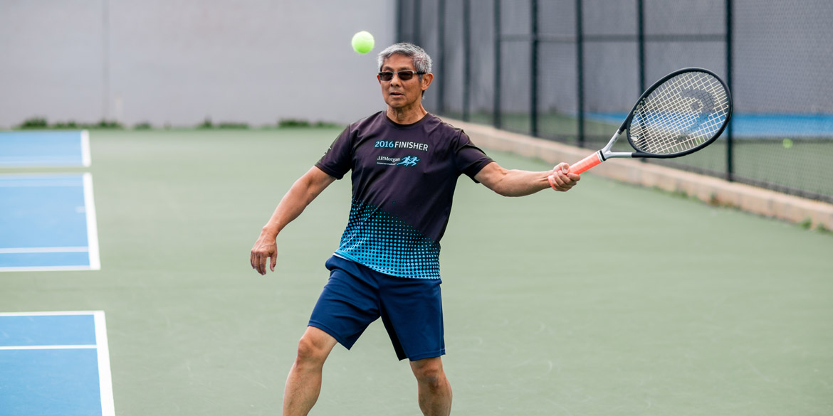 Adult athlete swinging at tennis ball Adult athlete swinging at tennis ball