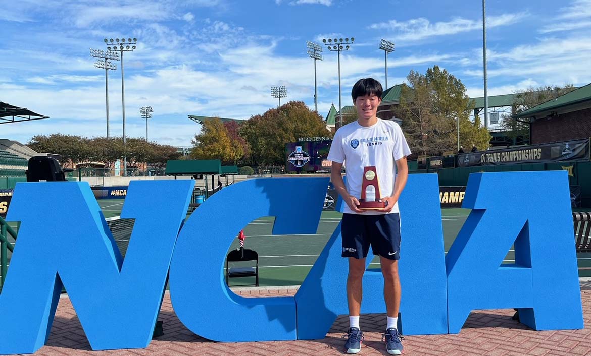 Columbia University's Michael Zheng lifts the 2024 NCAA men's singles title. Photo credit: Greg Sharko/Cracked Racquets.
