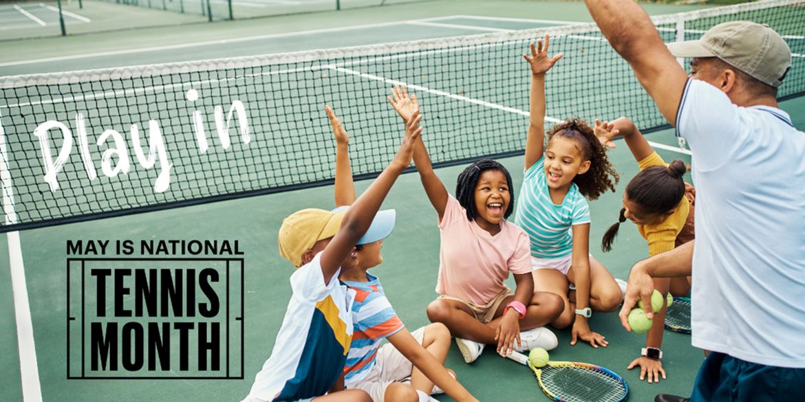 kids with hands raised on a tennis court